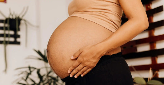 Future maman de 9 mois caressant son ventre arrondi prêt à accueillir bébé