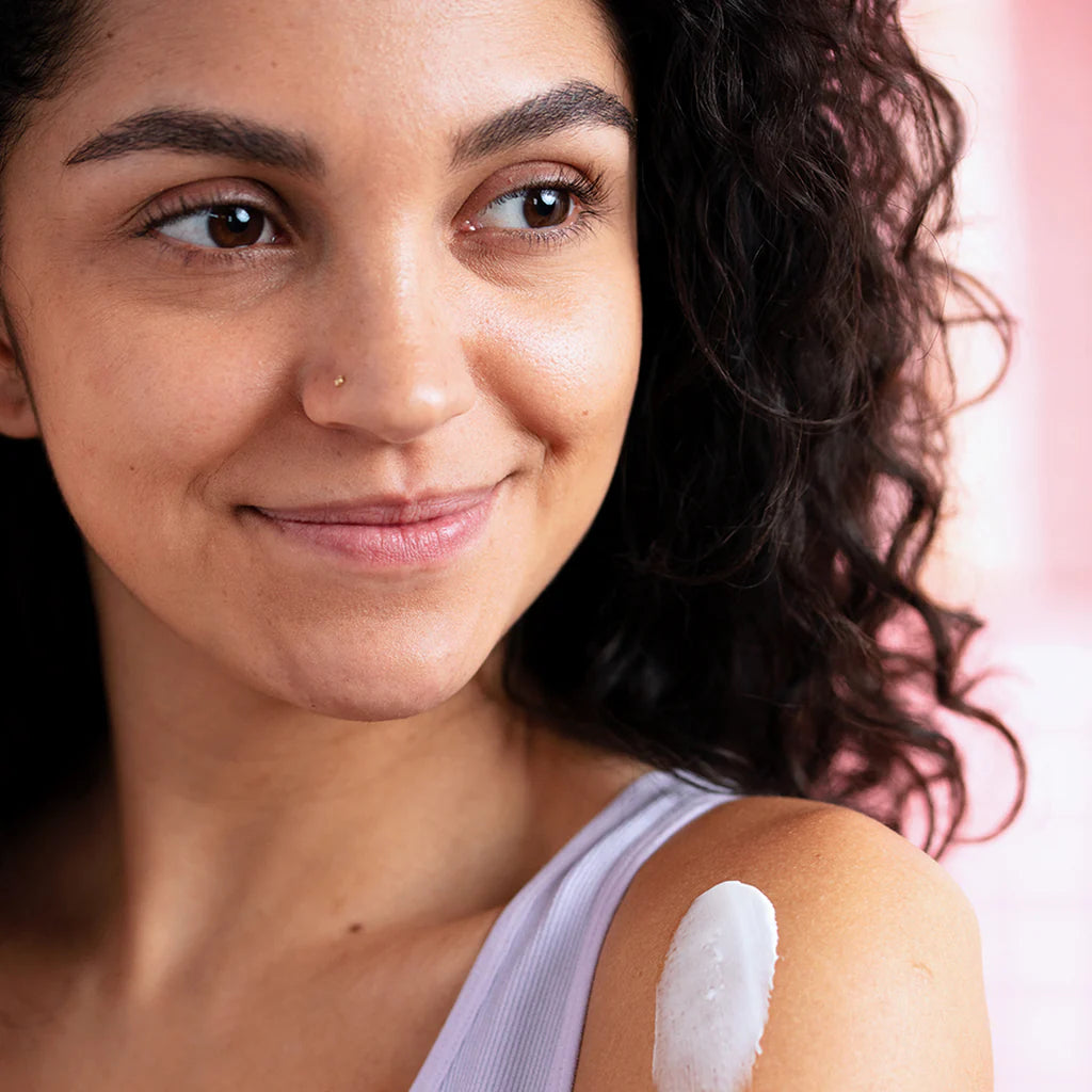 "Jeune femme appliquant la crème émolliente SVR Topialyse sur l'épaule pour apaiser une peau sèche et sensible. Soin hydratant 48h disponible sur laparadulac.com Tunisie."